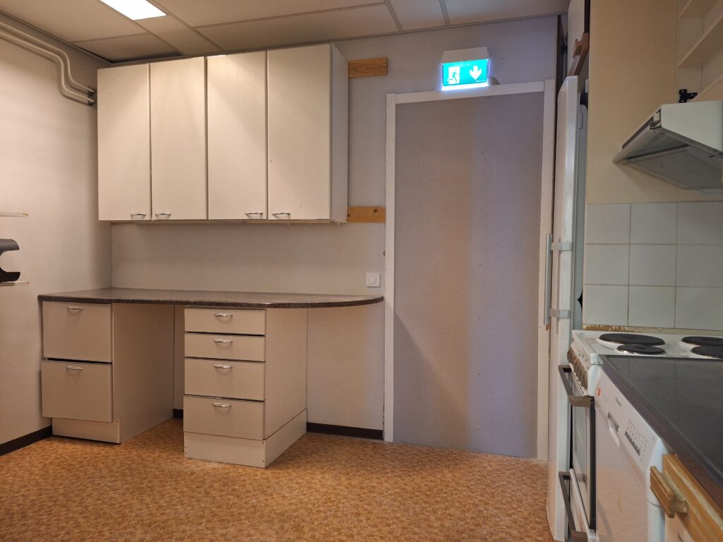 Tyhjä huone, kaapistoja ja oviaukko, liikehuoneistotilaa.