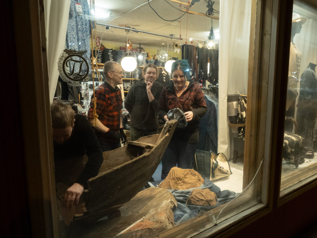 Ihmisiä farkkukauppa Vehkalan näyteikkunassa rakentamassa taideteosta.