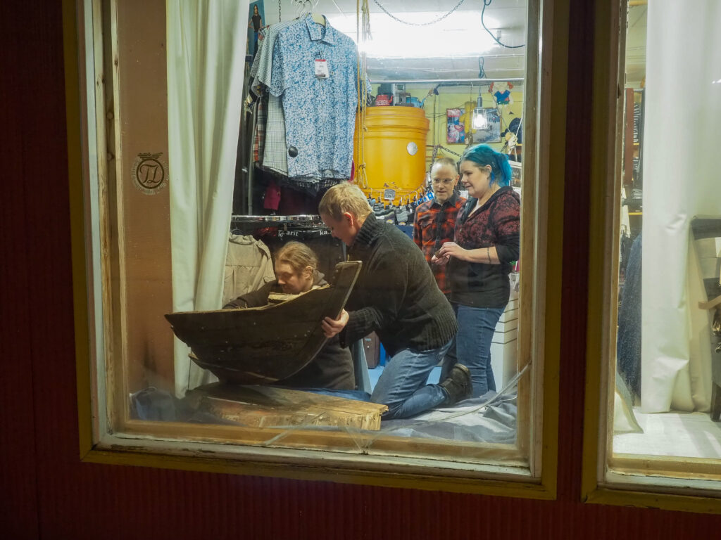 Neljä ihmistä rakentamassa farkkukauppa Vehkalan näyteikkunaan taideteosta.