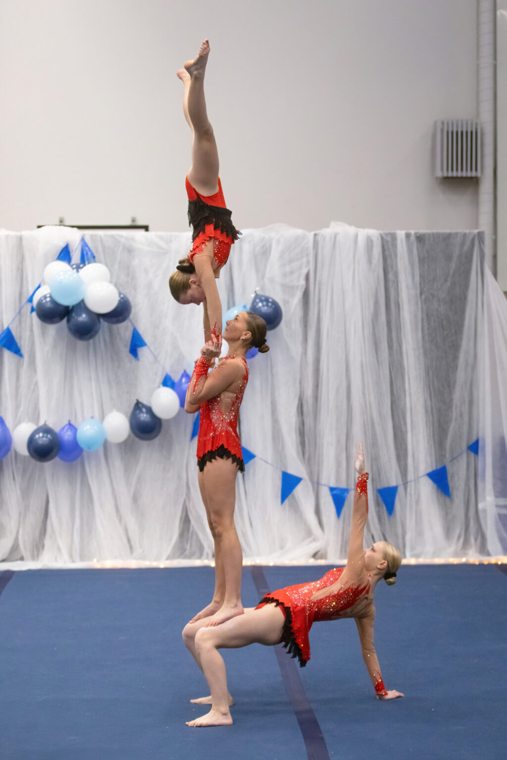 Kolmihenkinen akrobatiaryhmä esiintymässä.