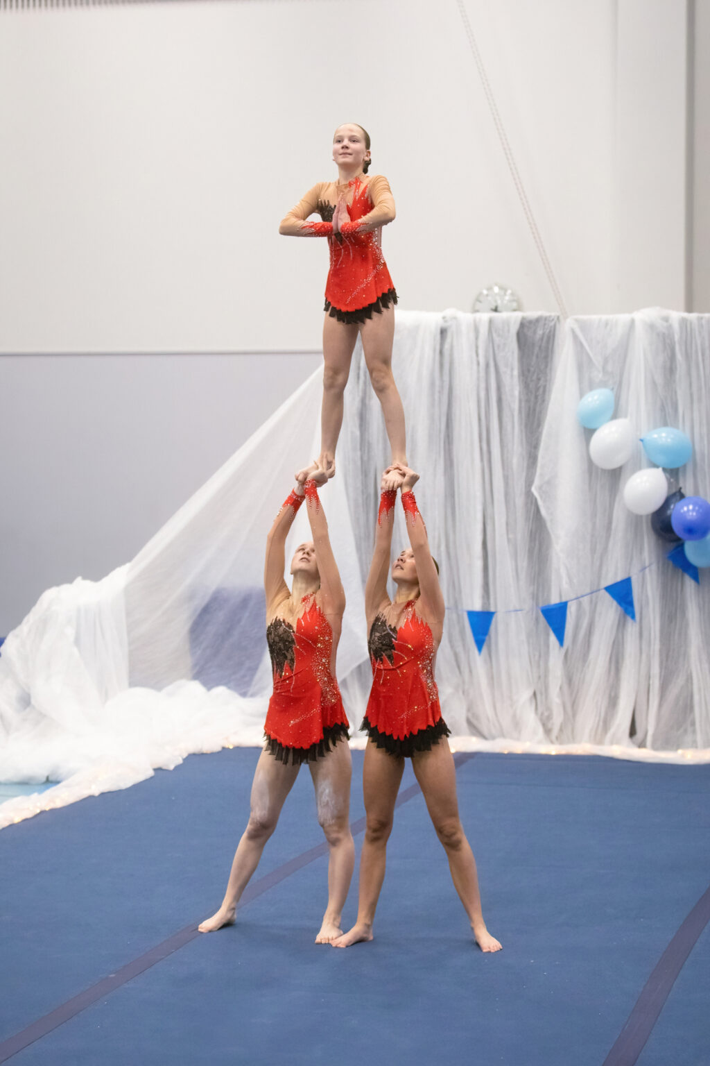 Kolmihenkinen akrobatiaryhmä esiintymässä.