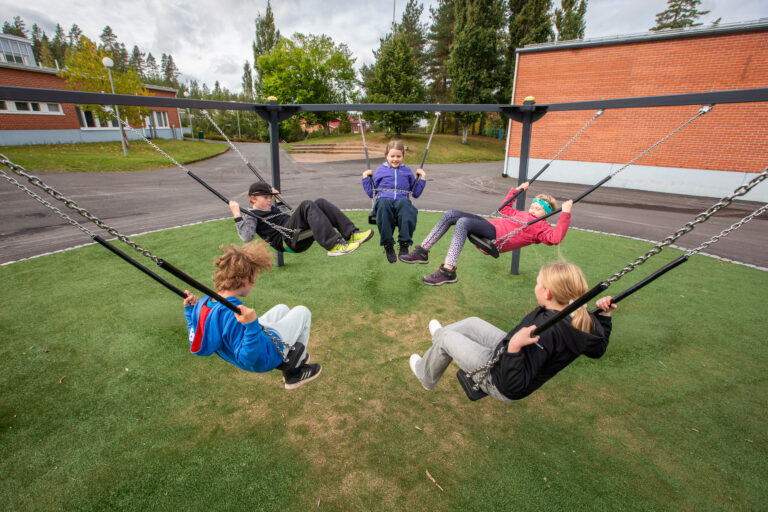Oppilaita keinumassa koulun pihalla Kuoreveden yhteinäiskoulussa