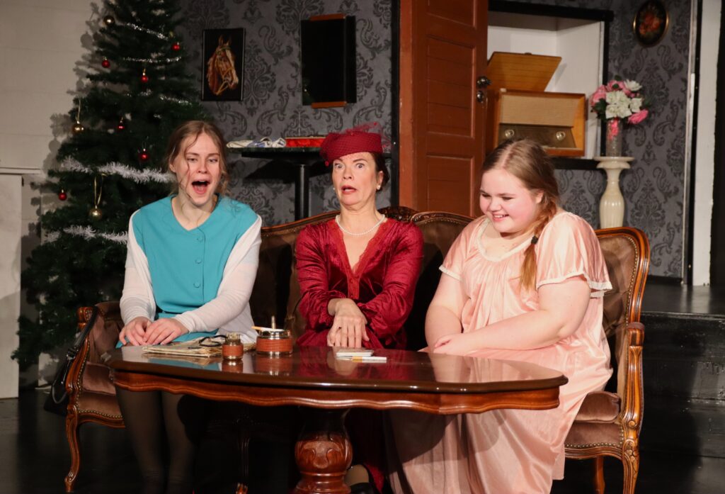 Kolme henkilöä teatterinäytelmässä lavalla, Teatteri Tenhon näytelmästä Kahdeksan naista.