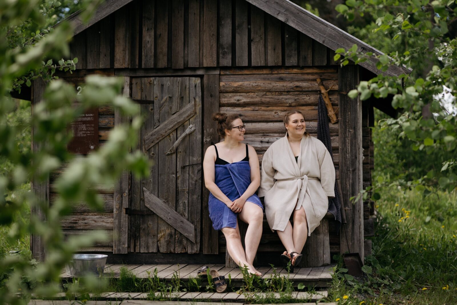 henkilöitä vanhan sauna edustalla.