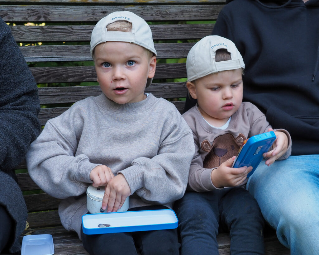 Kaksi lasta istumassa pihakeinussa.