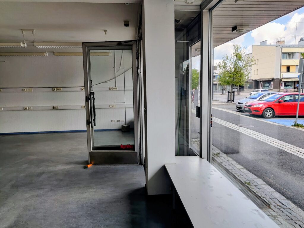 Liikehuoneiston sisätilaa, iso ikkuna josta näkymä kadulle.